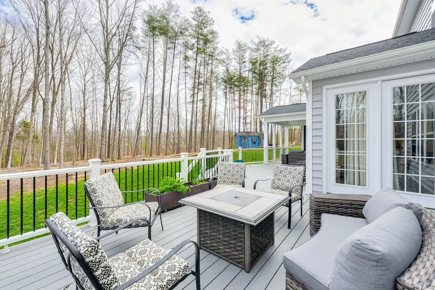 There is a fire pit on the deck of a house.