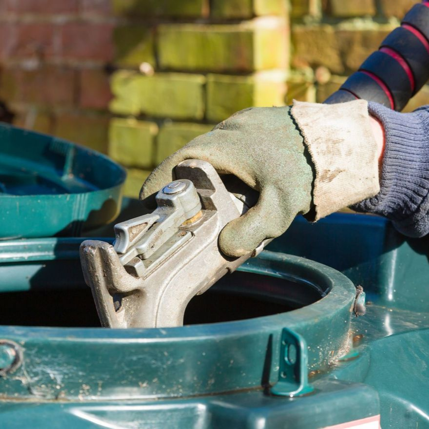 Main dans un gant de travail remplissant le réservoir d'huile de carburant.