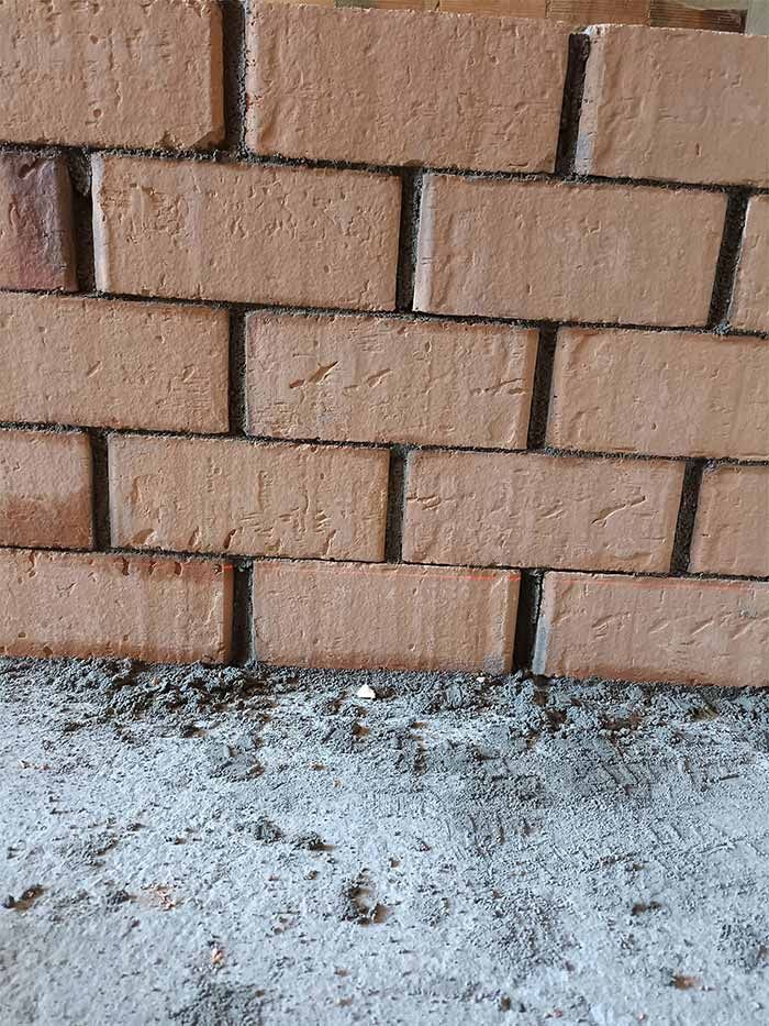 Un primer plano de una pared de ladrillos con muchos ladrillos sobre ella.