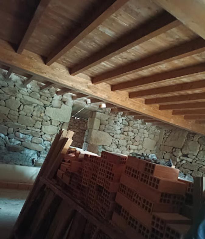 Una habitación con techo de madera y ladrillos en el suelo.
