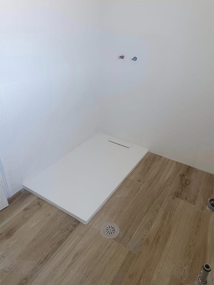 Un baño con cabina de ducha y suelo de madera.