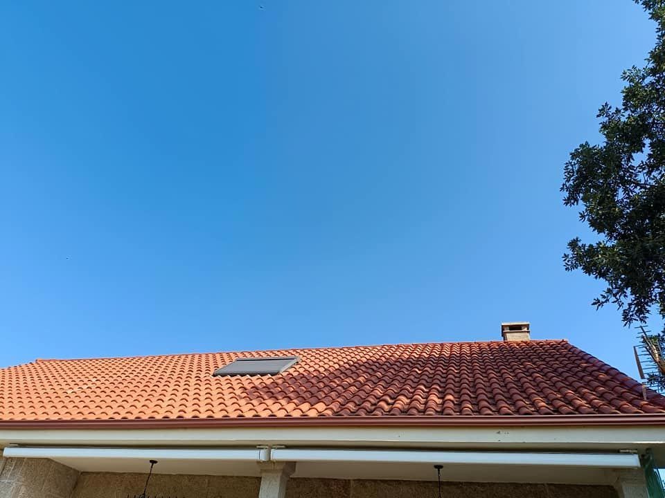Una casa con techo de tejas rojas y tragaluz.