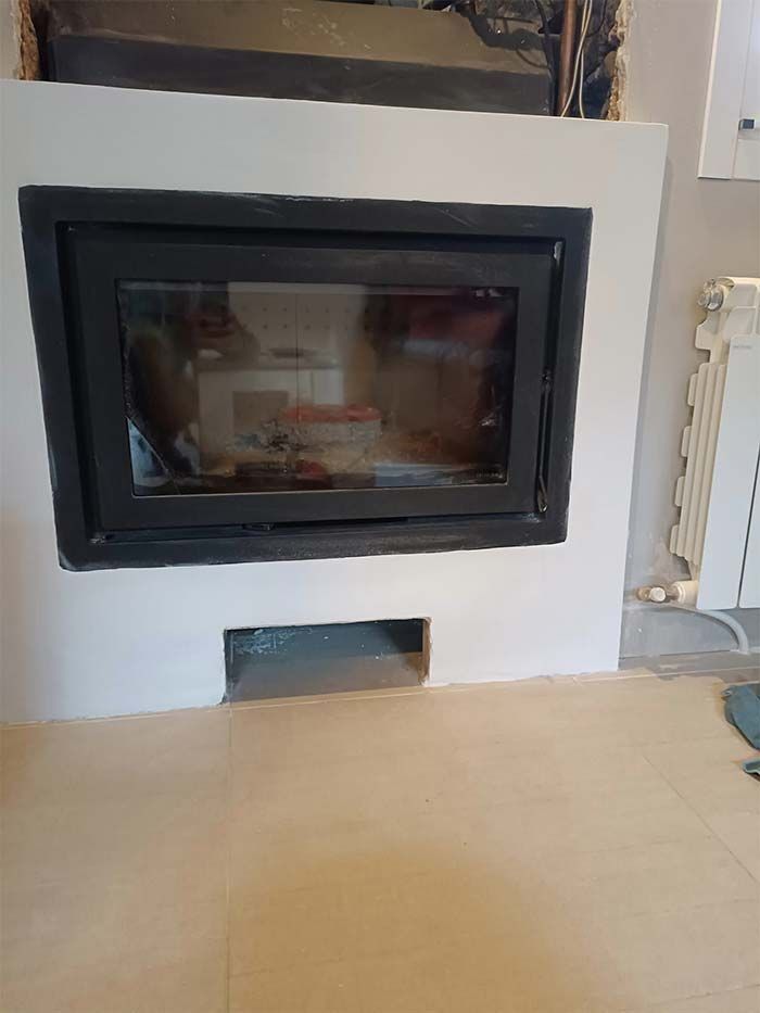 Una chimenea está empotrada en una pared en una sala de estar.