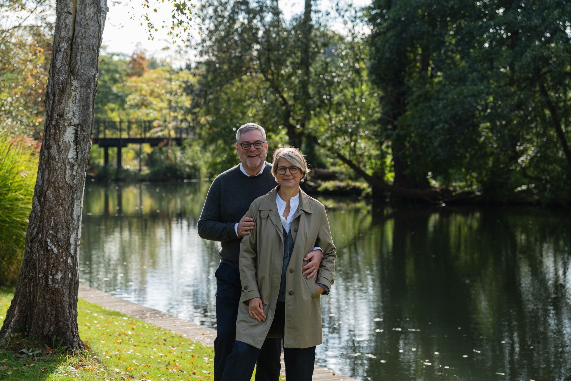 Ein Mann und eine Frau posieren vor einem See für ein Foto.