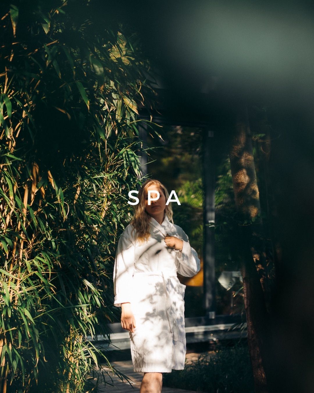 Eine Frau in einem weißen Gewand geht durch einen Wald.