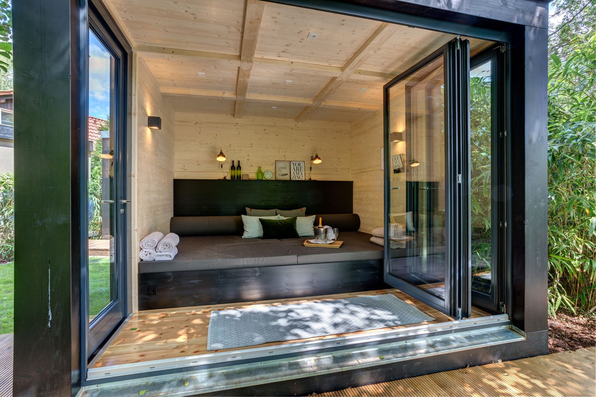 In der mitte des raumes mit vielen fenstern steht ein sofa.