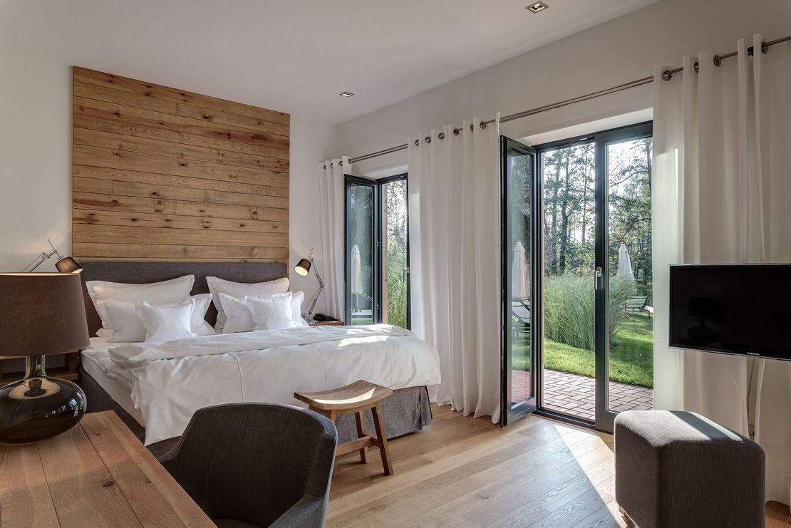 Ein Schlafzimmer mit großem Bett, Schreibtisch, Stuhl und Fernseher.