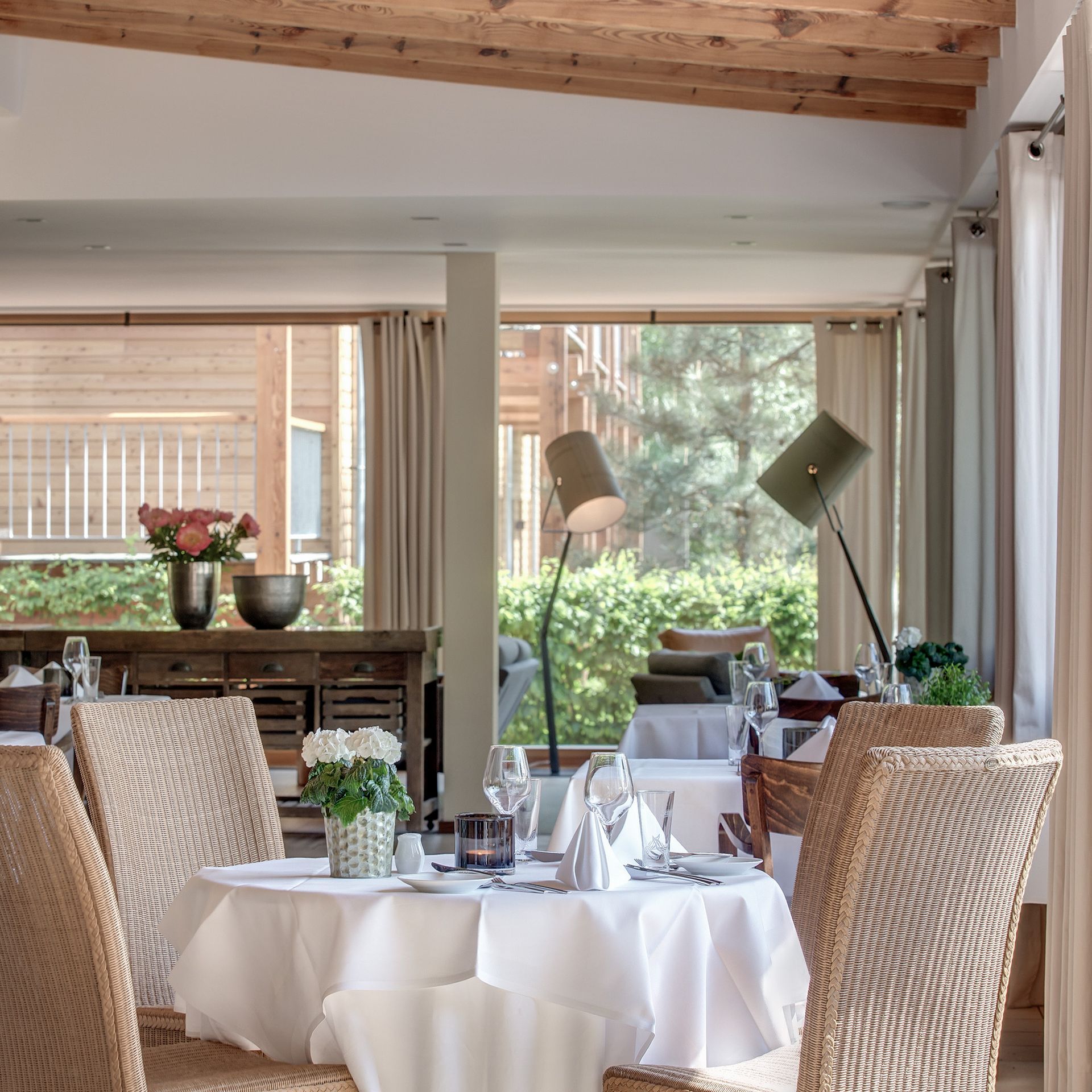 Ein Restaurant mit Korbstühlen und Tischen mit weißer Tischwäsche