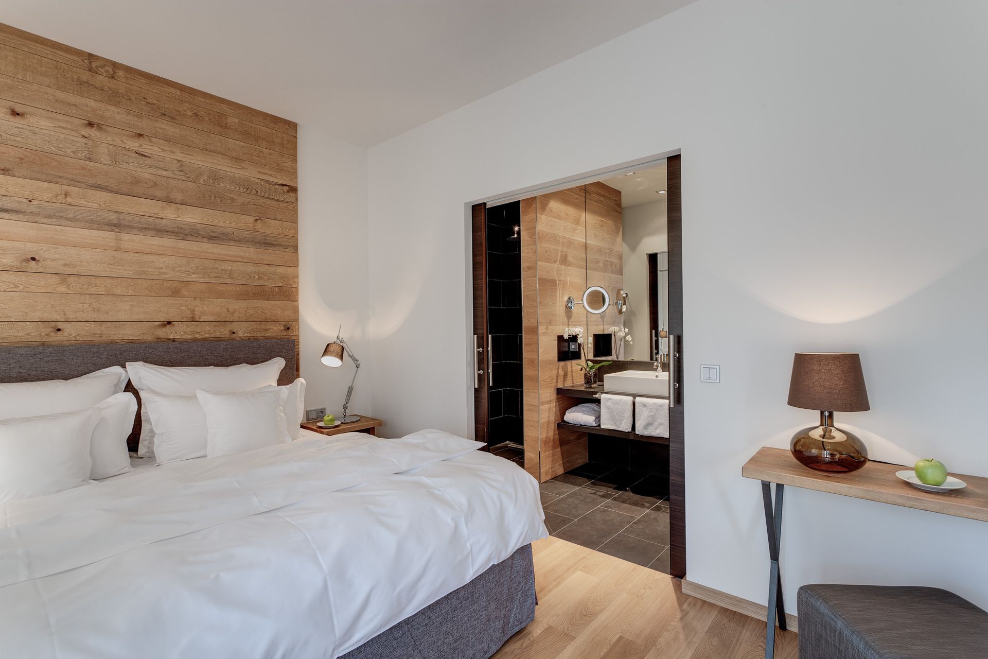 Ein Schlafzimmer mit einem großen Bett und einer Holzwand.