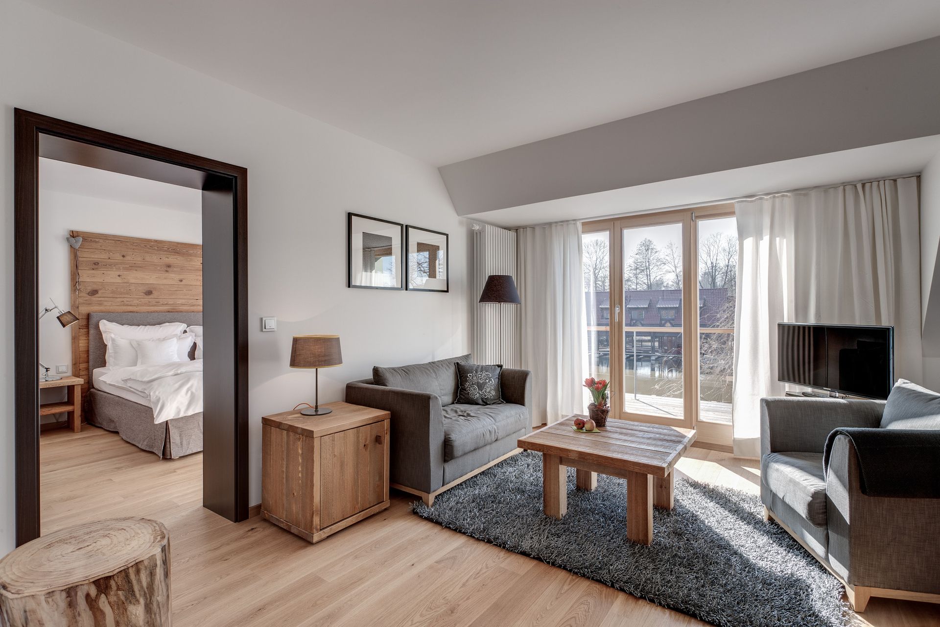 Ein Wohnzimmer mit Sofa, Sessel, Couchtisch und Fernseher.