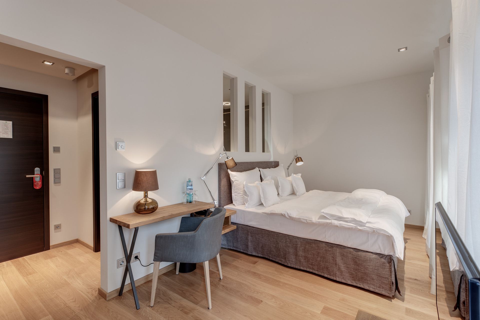 Ein Hotelzimmer mit großem Bett, Schreibtisch und Stuhl.