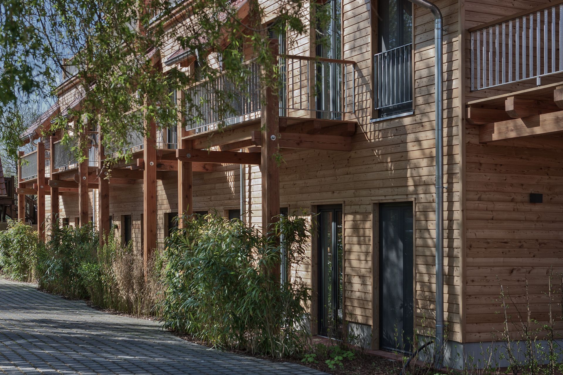 Eine Reihe von Holzhäusern mit Balkonen und Bäumen davor