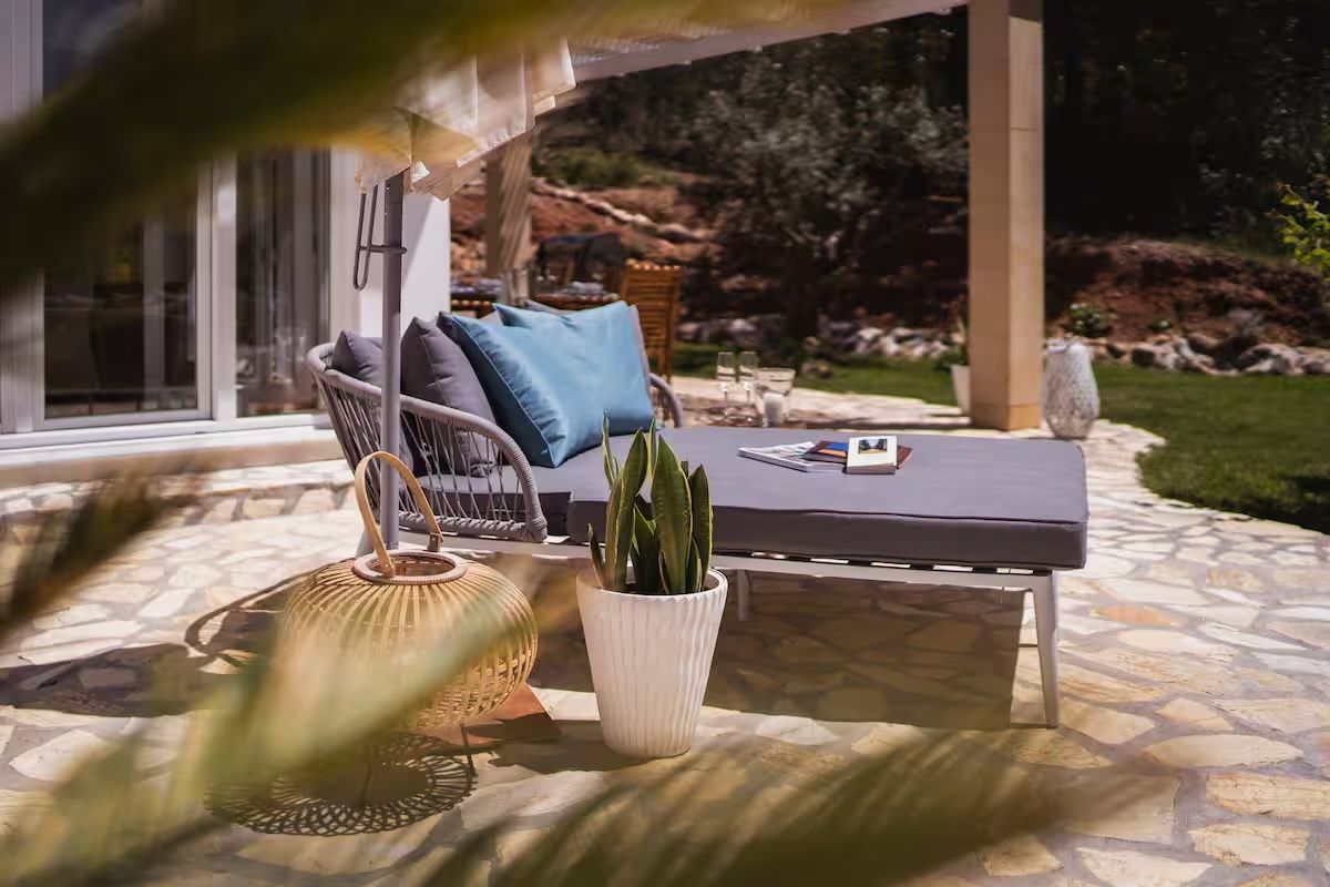 Outdoor lounge bed with cushions on the covered stone terrace