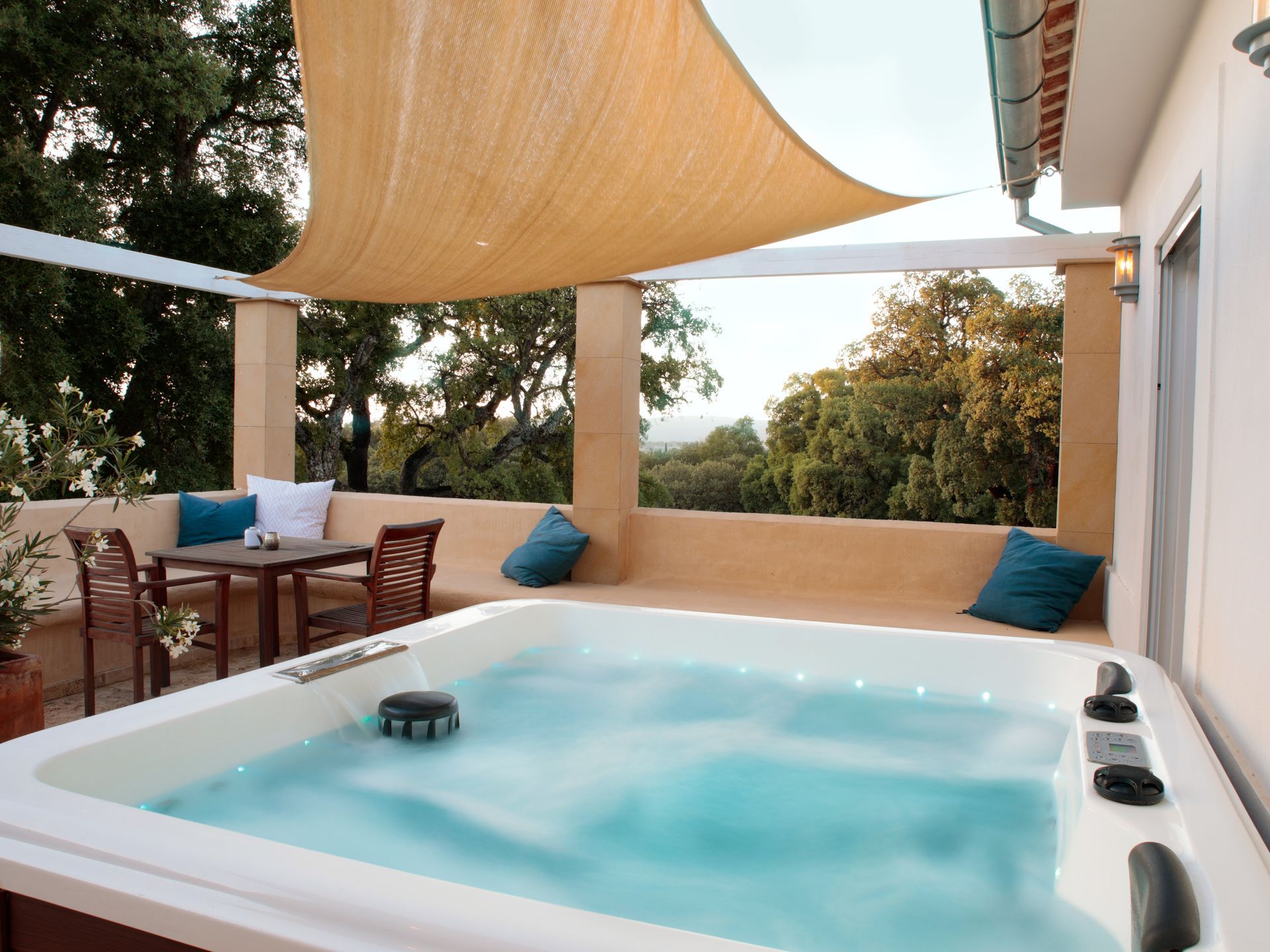 Jacuzzi on a shaded terrace with sun sail and outdoor seating