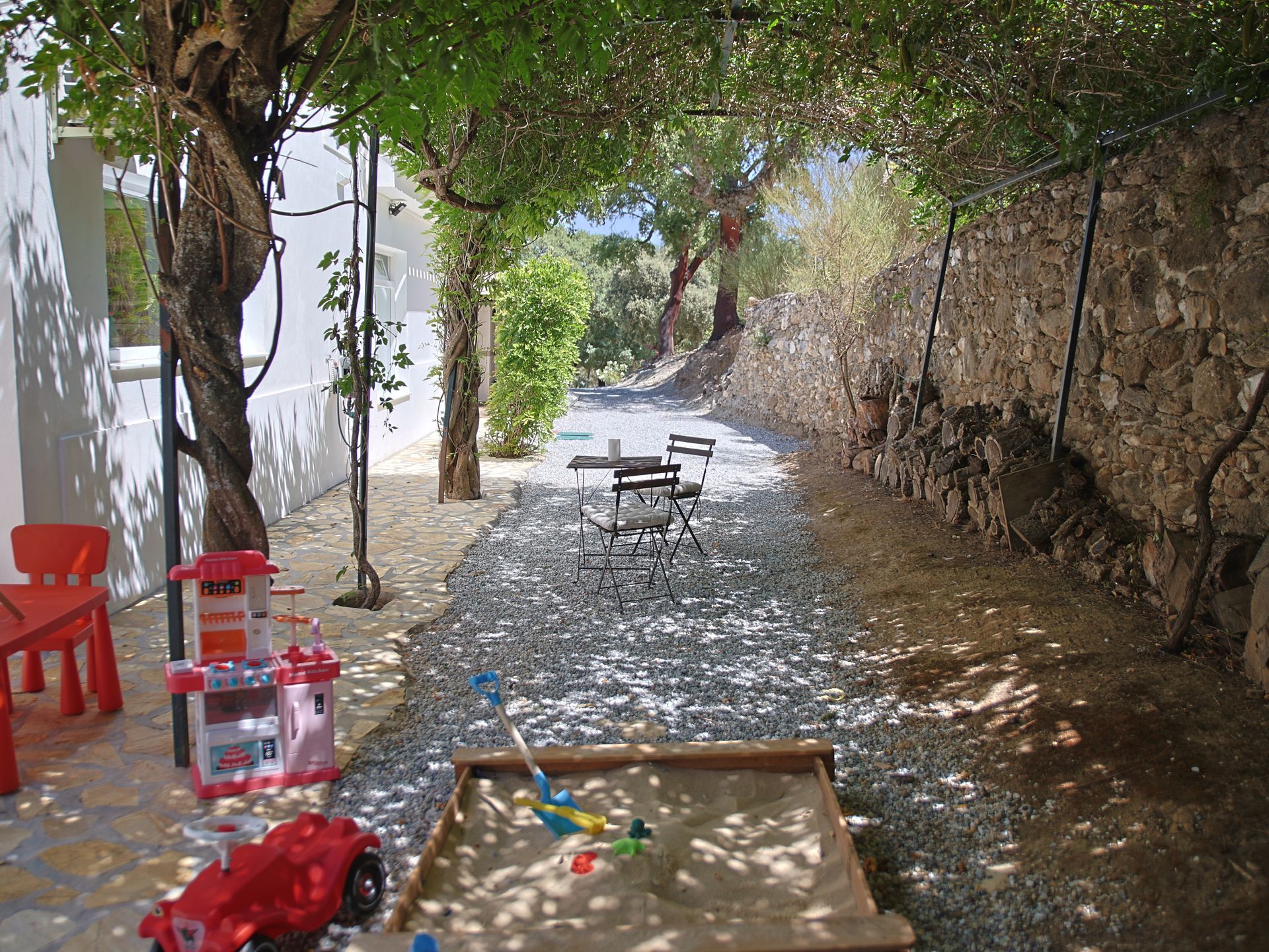 Shady garden path with bistro table and children's chairs under the trees