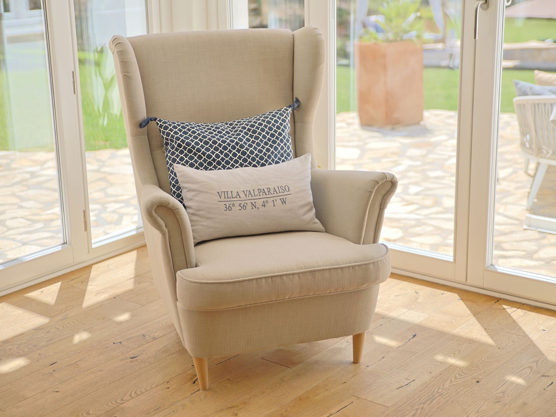 Wingback armchair with Villa Valparaiso cushion by the garden windows