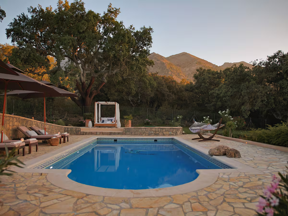 Pool at dusk with canopy daybed and mountain views in Andalusia