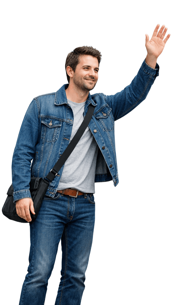 Une personne vêtue d'une veste en jean et d'un jean se tient debout, souriante, faisant un signe de la main droite tout en portant un sac messager noir.