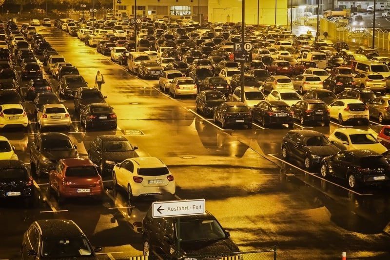 A lot of cars are parked in a parking lot at night.