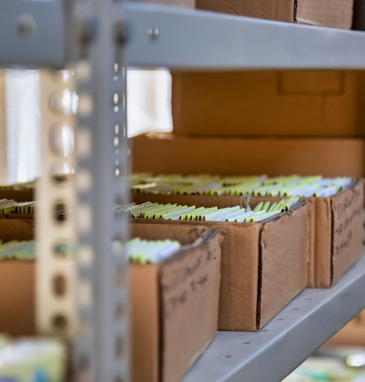 Étagère avec des boîtes en carton remplies de dossiers.