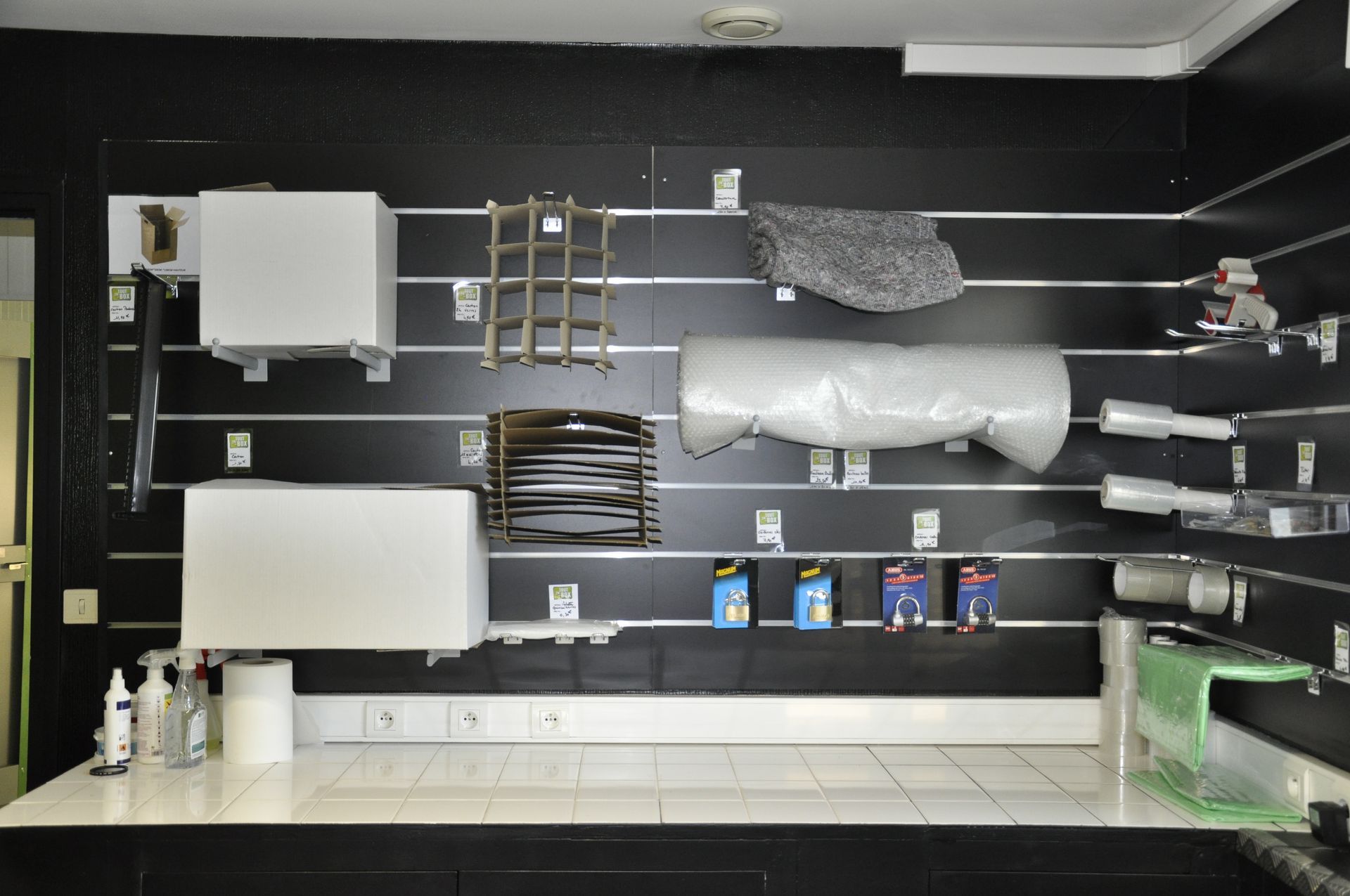 Main tenant une carte de sécurité noire près d'un lecteur sur une surface métallique, probablement pour le contrôle d'accès.