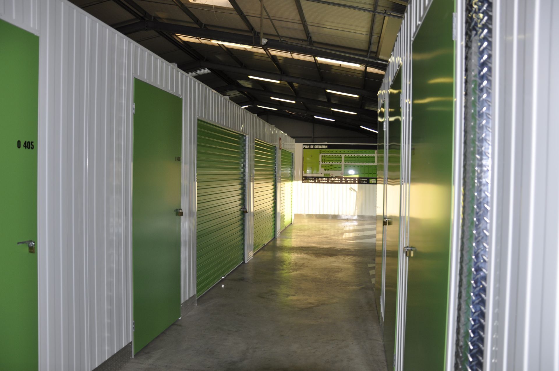 Fresque représentant un colibri, une machine à laver, un ours en peluche et des boîtes sur fond vert.