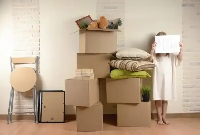 Des conteneurs de stockage en tôle ondulée blanche avec une porte verte ouverte. À l'intérieur, on aperçoit un autre conteneur.