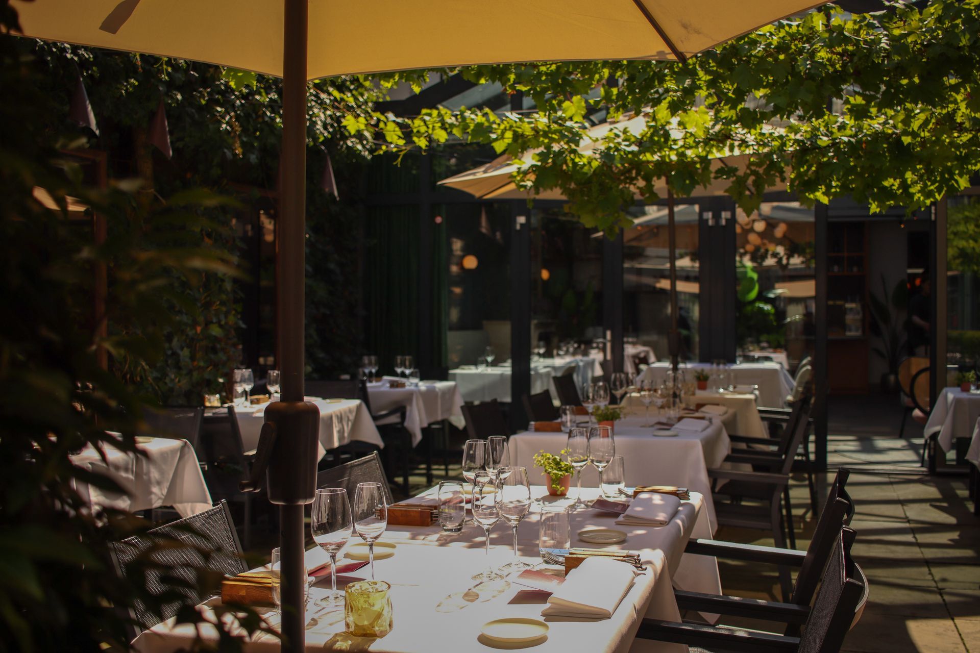 Een restaurant met tafels en stoelen onder parasols