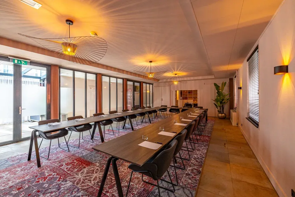 Een grote kamer met een lange tafel en stoelen.