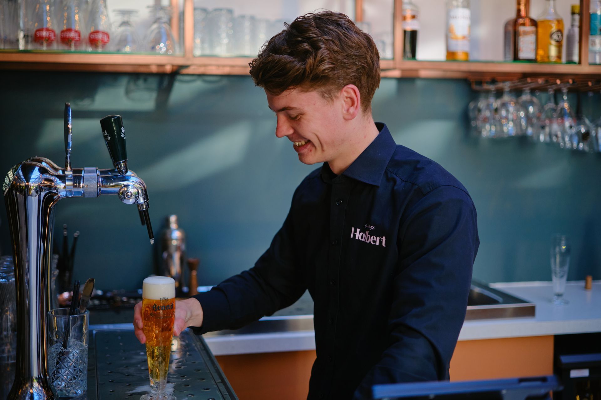 Een man schenkt bier in een glas in een bar.