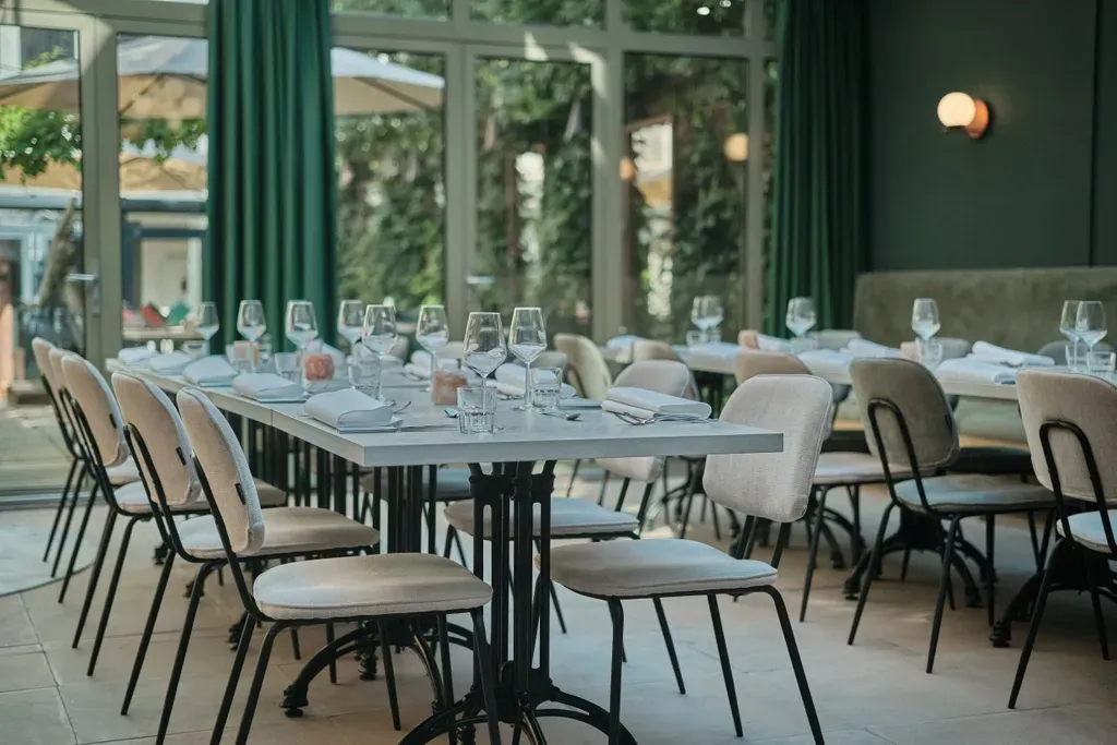 Een restaurant vol tafels, stoelen en glazen wijn.