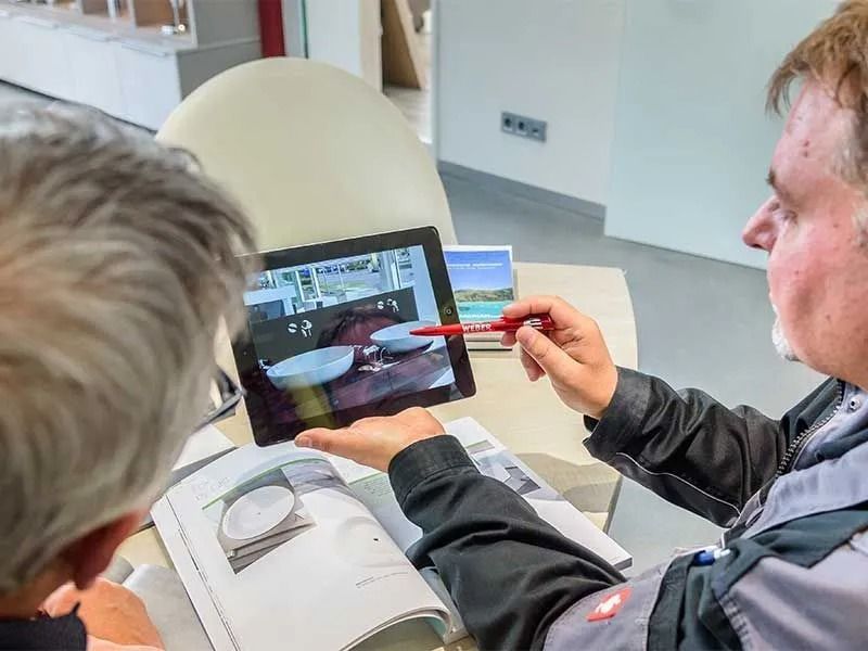 Badberatung mit Tablet: Kunde und Berater besprechen die Planung eines Badezimmers.