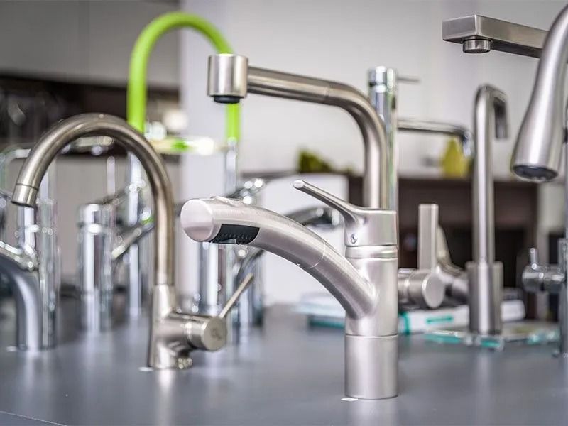 Ausstellung moderner Küchen- und Badarmaturen mit verschiedenen verchromten Wasserhähnen.