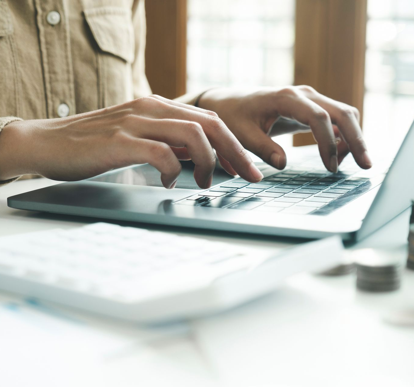 Des mains tapent sur le clavier d'un ordinateur portable