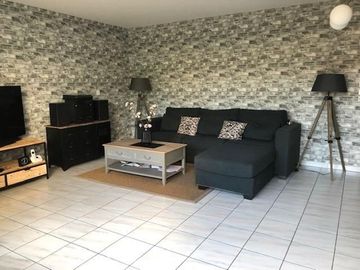 Salon moderne avec une tapisserie imitation brique.