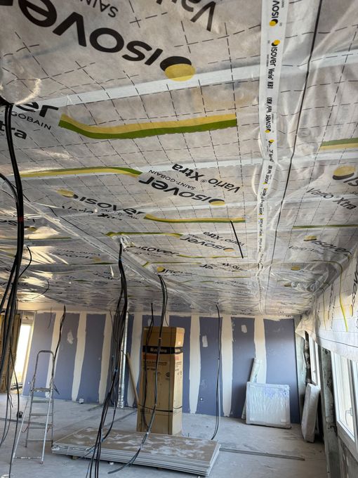Pièce en travaux avec isolation apparente et fils électriques.