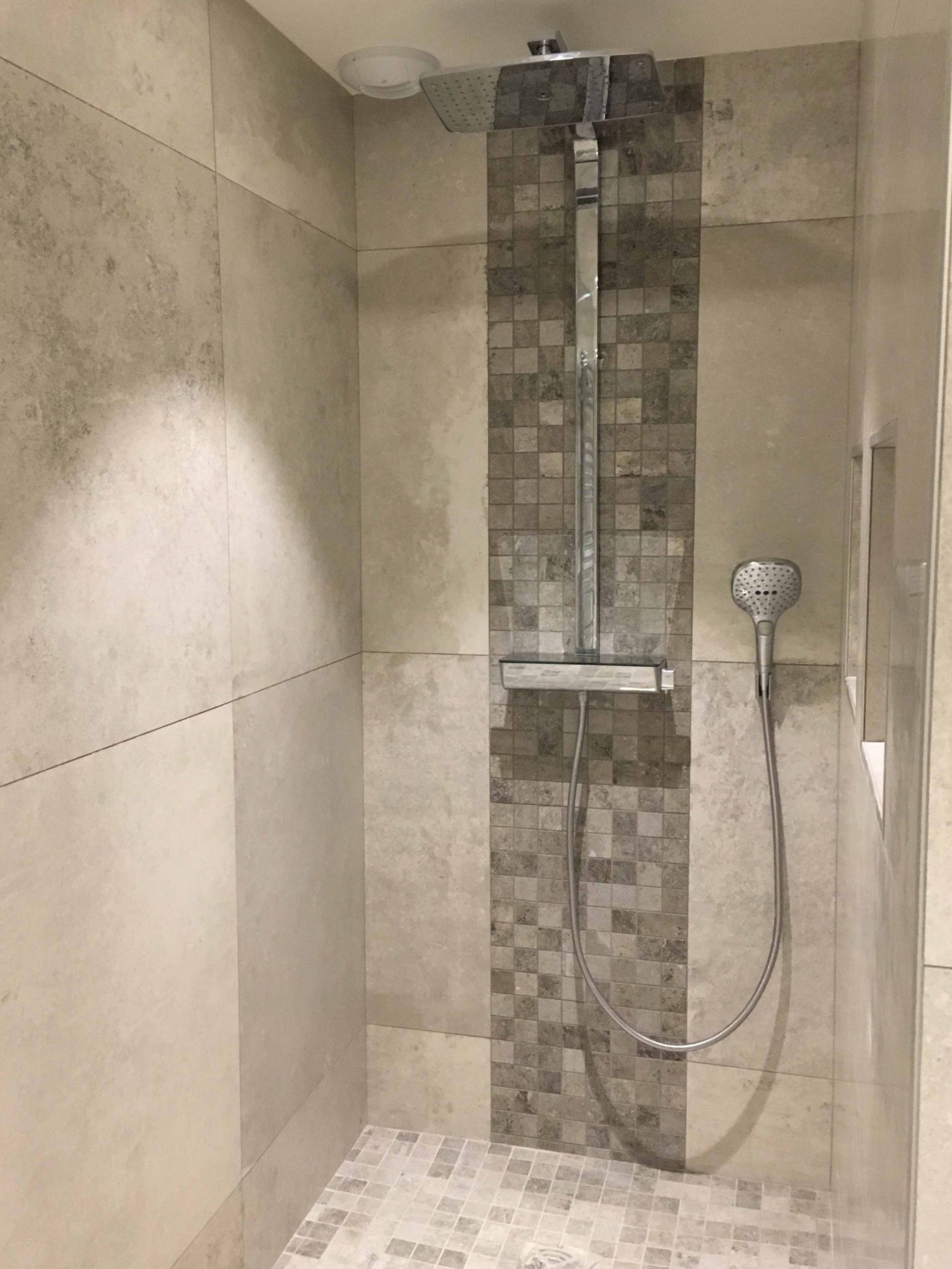 Douche moderne avec murs carrelés et frise décorative en mosaïque