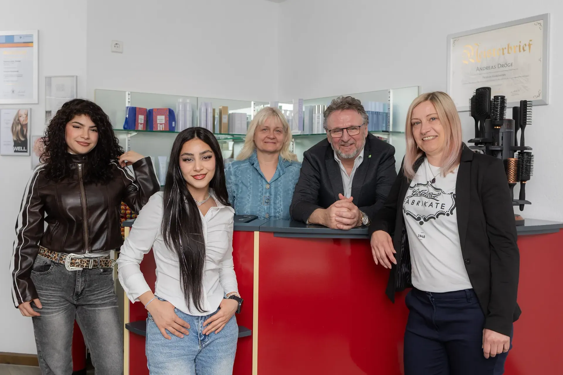 Eine Gruppe von Menschen posiert in einem Salon für ein Foto.