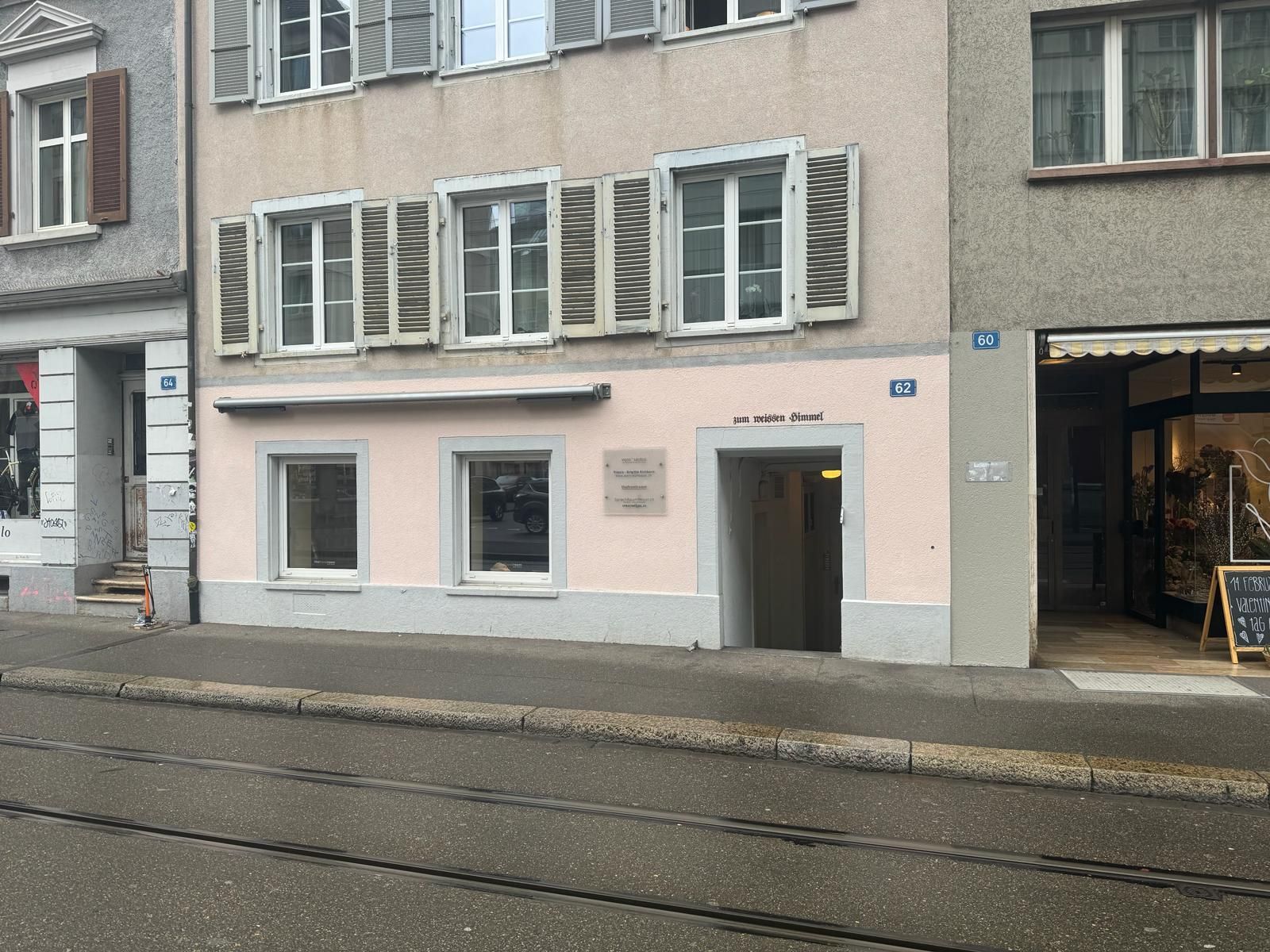 Ein Gebäude mit vielen Fenstern liegt an einer Straße.
