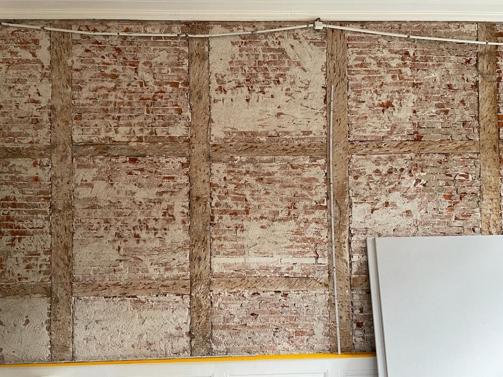 Eine Ziegelwand mit einer weißen Tafel davor