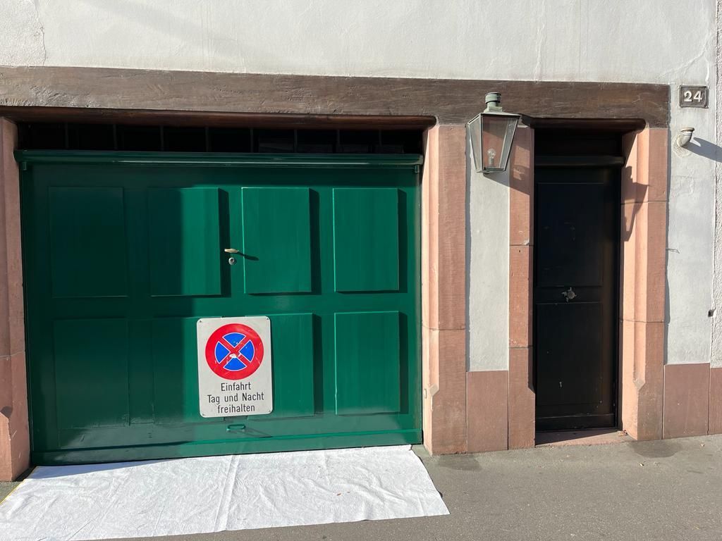 Ein grünes Garagentor mit einem Parkverbotsschild darauf