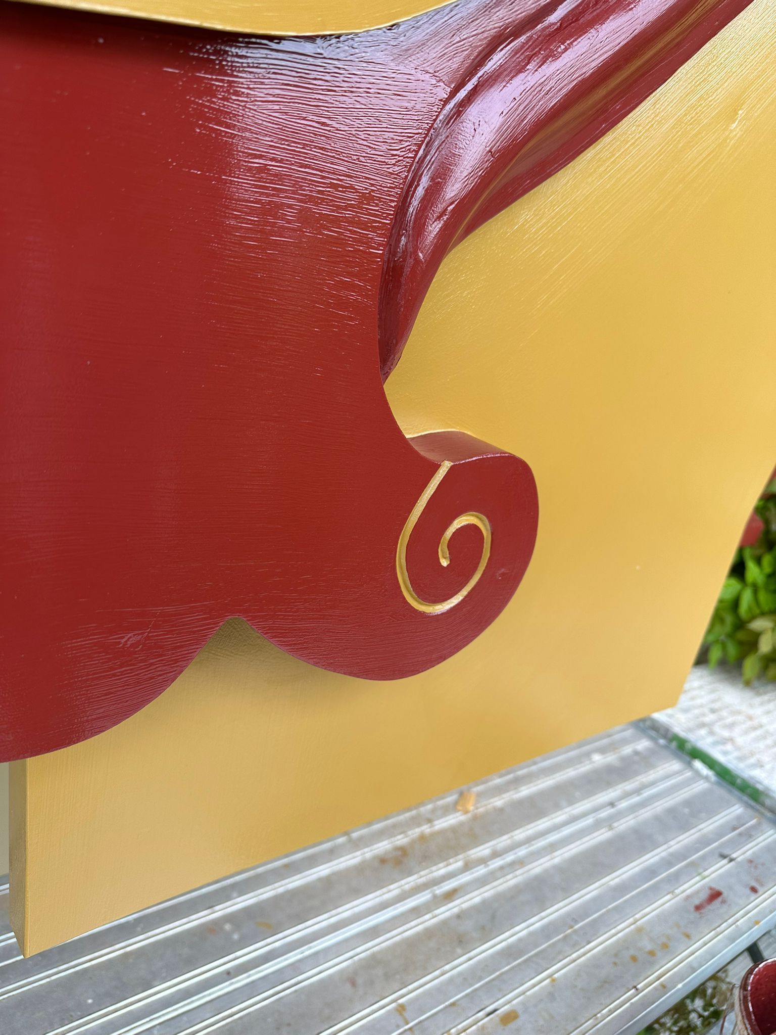 Eine Nahaufnahme eines rot-goldenen Schlittens mit einem Wirbel an der Seite.