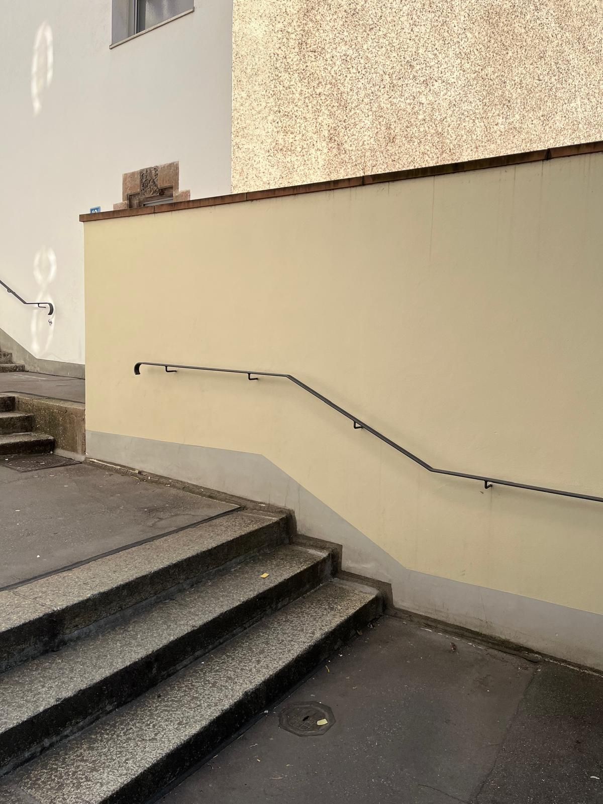Eine Treppe, die zu einem Gebäude mit Geländer hinaufführt.