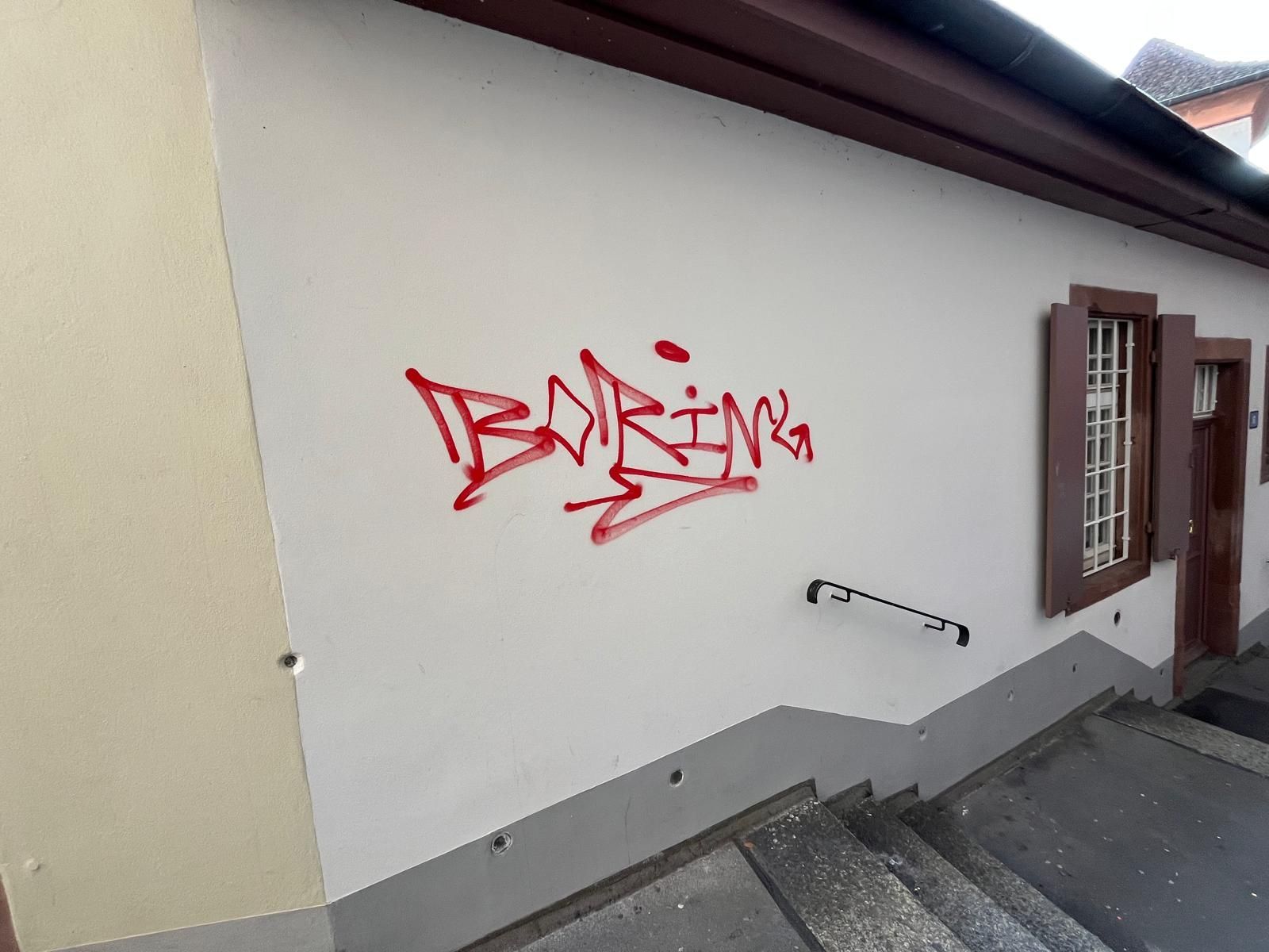 Ein weißes Gebäude mit roten Graffiti an der Seite