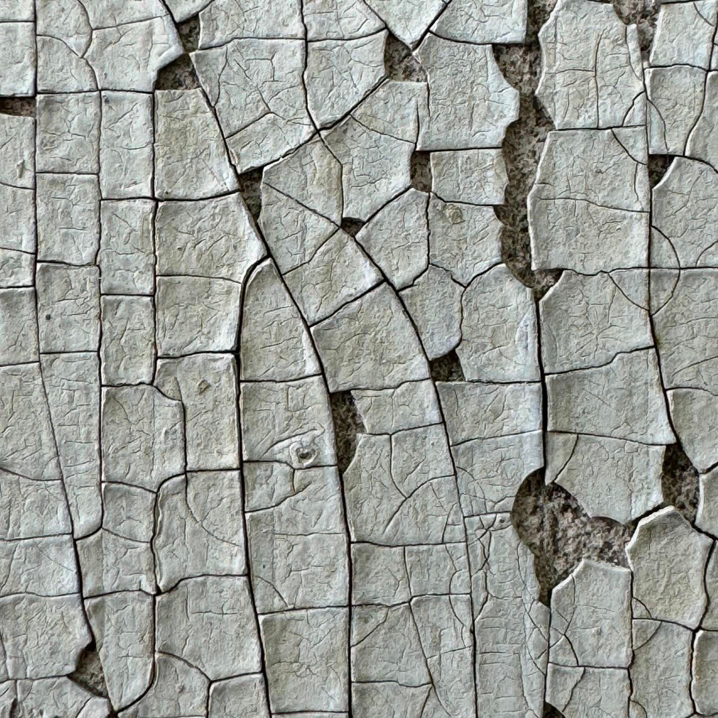 Eine Nahaufnahme einer rissigen weißen Wand.