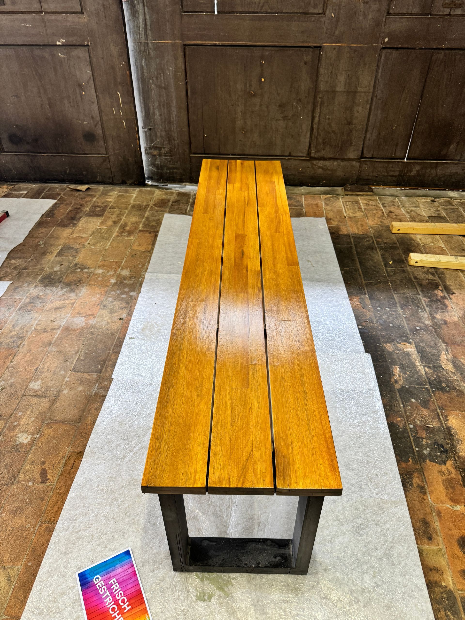 In einem Zimmer steht eine Holzbank auf einem Teppich.