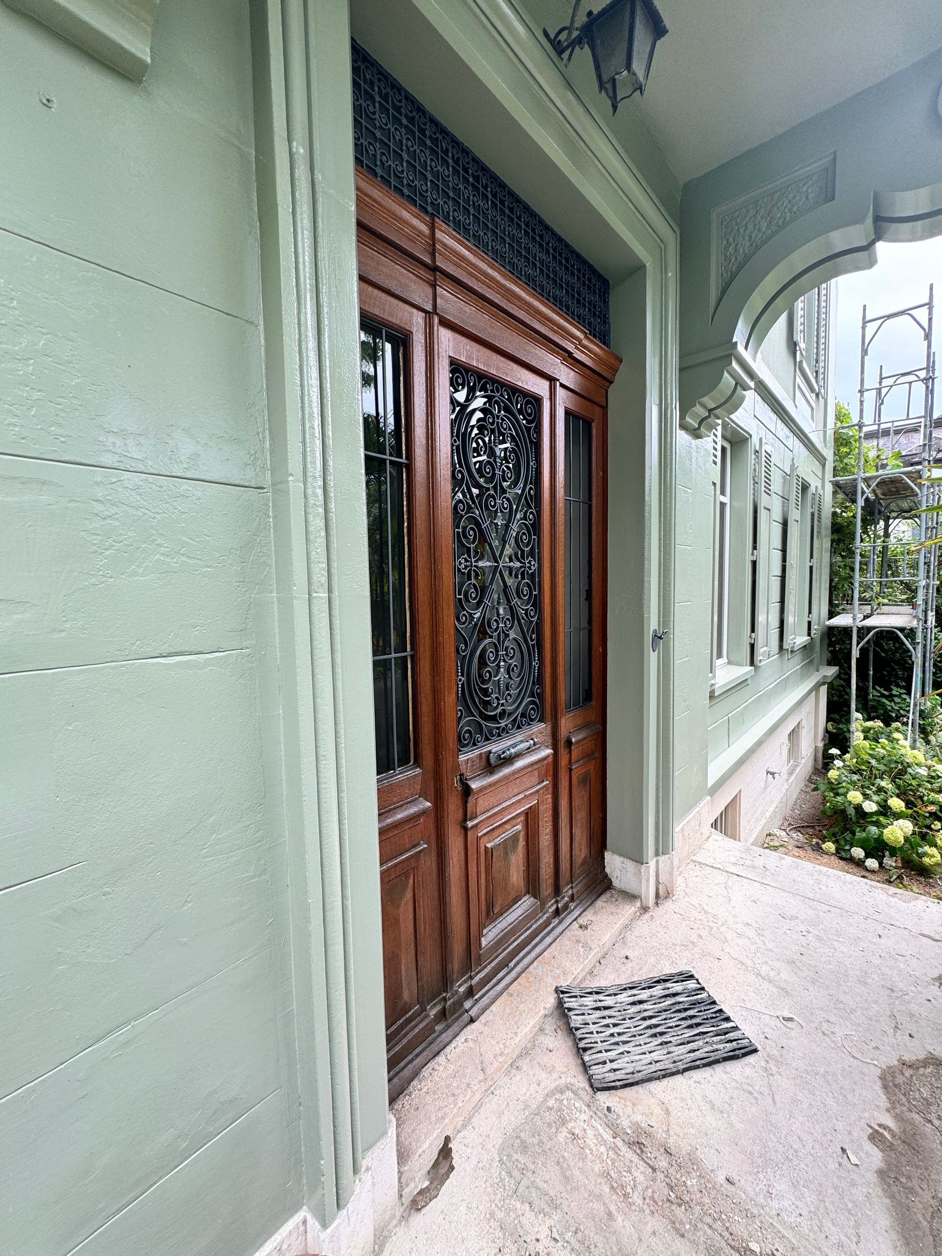 Die Eingangstür eines Gebäudes mit einer Fußmatte auf dem Boden.