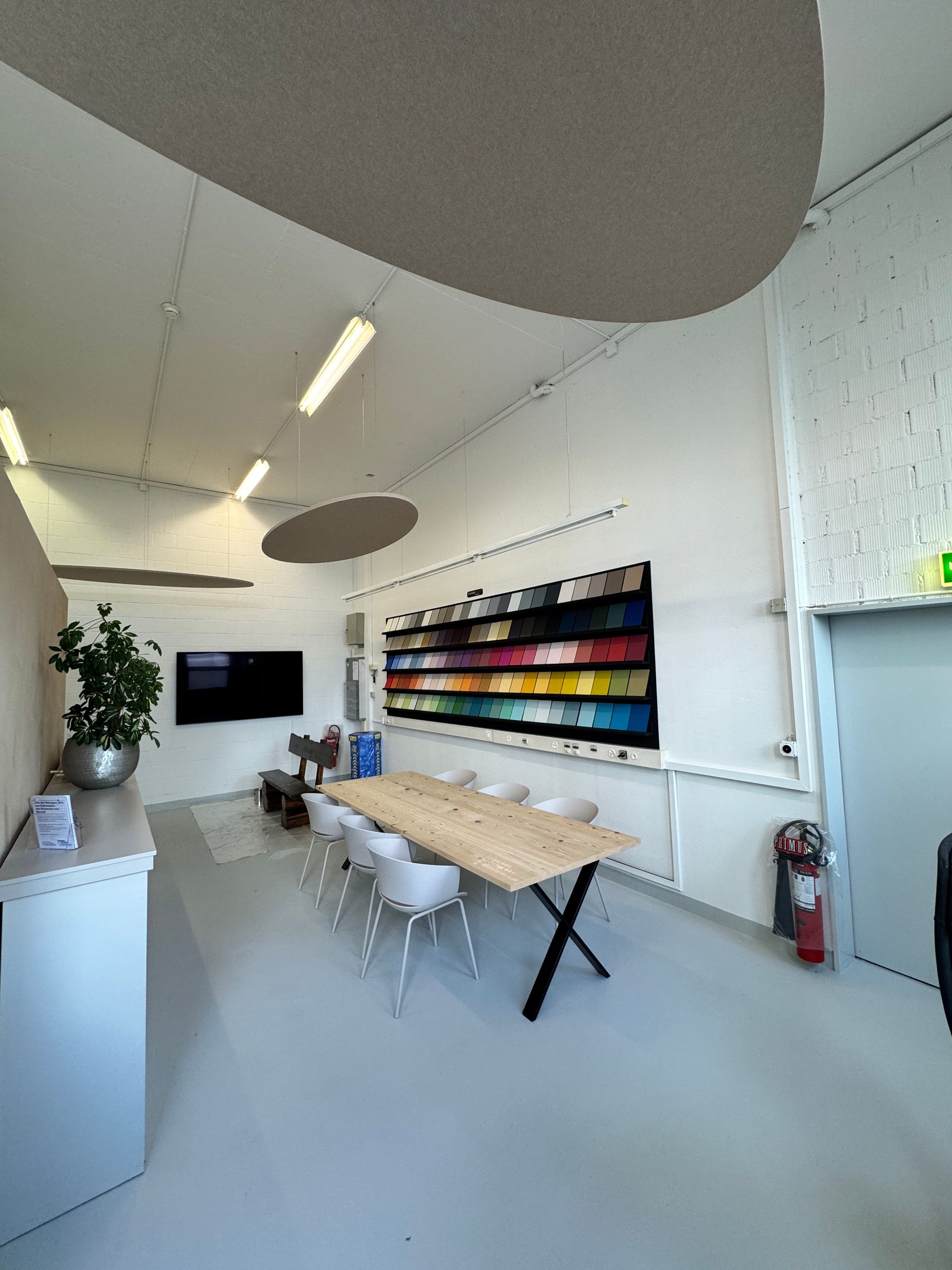 Ein Raum mit einem Tisch und Stühlen und einem Fernseher an der Wand.