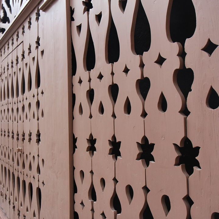 Ein Holzzaun mit einem Muster aus Blumen und Blättern