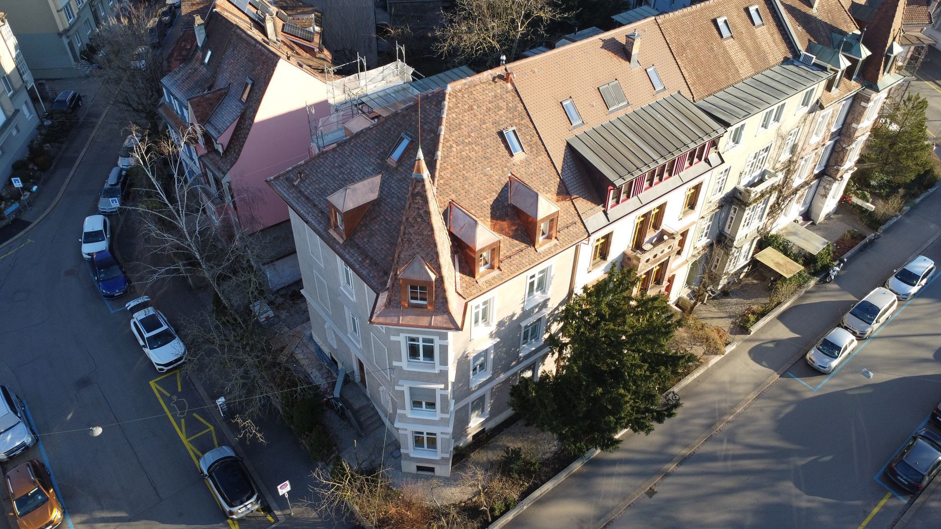 Eine Luftaufnahme eines Gebäudes mit davor geparkten Autos.